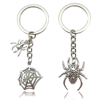 Two silver-tone keychains displayed with spider web and textured spider charms.