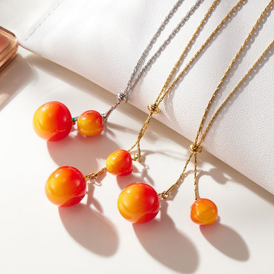 Gold cherry resin dual pendant necklace worn on model