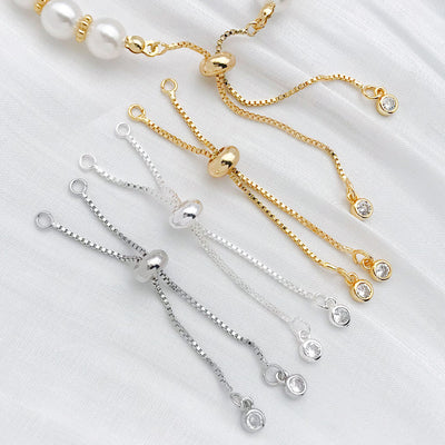 Adjustable slider extension chains with clear stones arranged as a full product overview