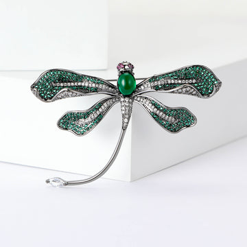 Green Dragonfly Metal Brooch with Dark Green Wings, a Pink Center Stone, and Curved Tail