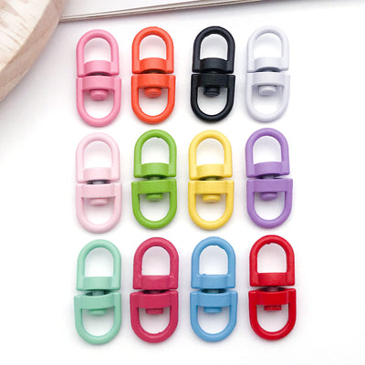 Colorful swivel clasp jewelry findings arranged on a light background