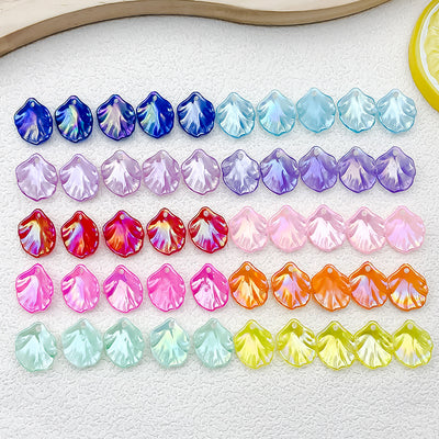 Iridescent shell and flower charms arranged on a light background