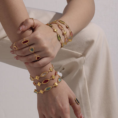 Stacked gold heart marquise glass bracelets on wrists
