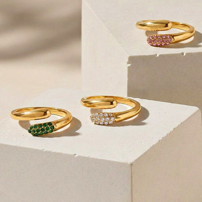Three gold open bypass rhinestone rings pink white green on blocks