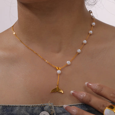 Gold pearl whale tail Y-necklace worn on a collarbone