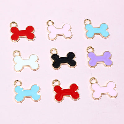 Assorted colorful enamel bone charms with top loops arranged together on a plain background