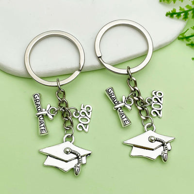 Image 1 showing two key chains with graduation charms.