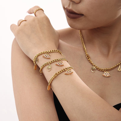 Model wearing gold curb Christmas bracelets and necklace with zircon bells