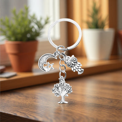 Tree moon star and owl keychain in a warm tabletop setting