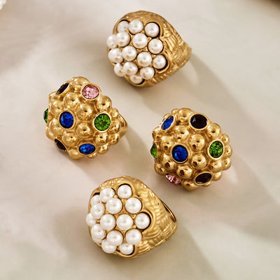 Styled hand view of oversized pearl and gemstone cluster rings in main image 1.