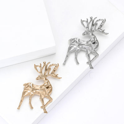 Gold and silver geometric faceted stag deer brooches on white blocks