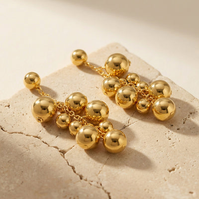Display view of gold tone graduated ball cluster earrings in main image 1.