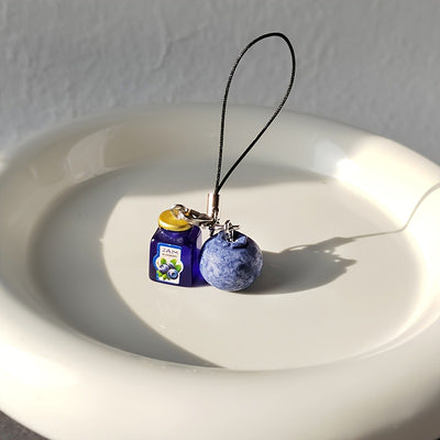 Resin blueberry and blue jam jar phone charm on white dish