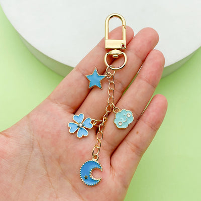 Image 1 showing a hand holding a key chain with charms.