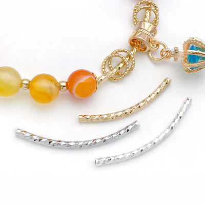 Gold-tone fish beads arranged on a light background
