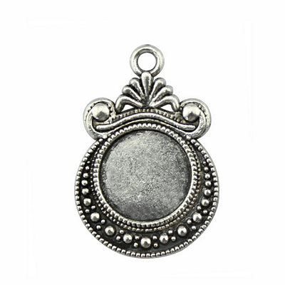 Ornate Round Cabochon Pendant Settings in Two Finishes held in hand for scale