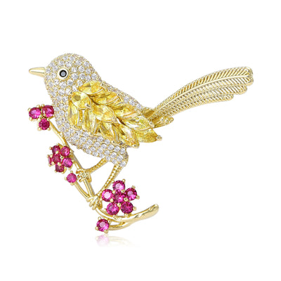 Front view of yellow Crystal Bird Brooch Perched on Pink Flower Branch against a white background.
