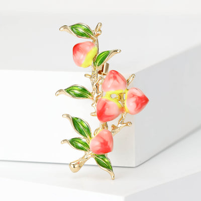 Pink Enamel Peach Fruit Branch Brooch With Glossy Green Leaves shown from the front on a white background
