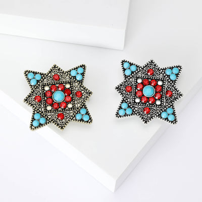 Product display showing a square star-shaped filigree frame with red and turquoise cabochons