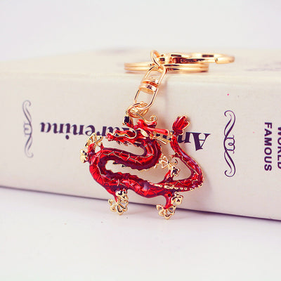 Red Chinese dragon pendant keychain resting against a white box.