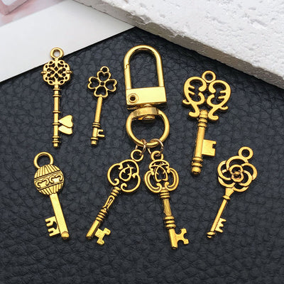 Matte gold-tone heart and four-leaf clover charms shown in a close-up product view