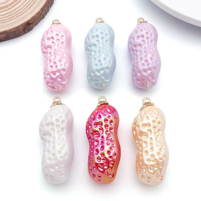 Iridescent peanut charms arranged on a light background