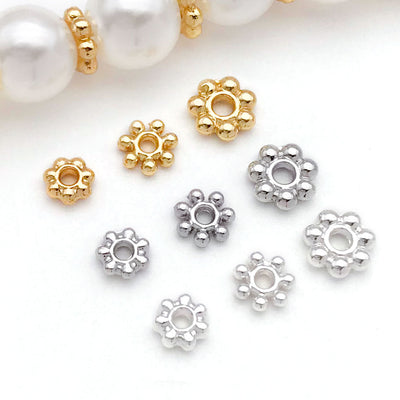 Gold-tone spacer bead beads arranged on a light background