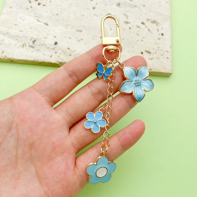 Image 1 showing a hand holding a blue flower charm.