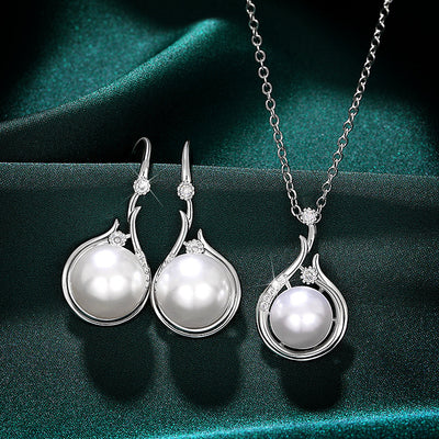 Silver pearl wave earrings and matching pendant necklace on green fabric