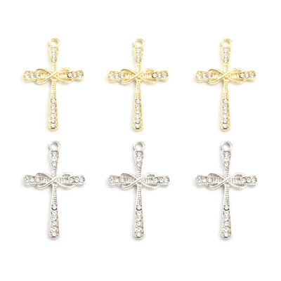 Assorted cross charms arranged on a white surface