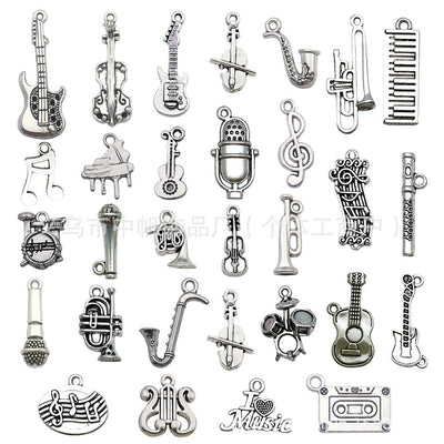 Antique silver musical instrument charms arranged on a light background