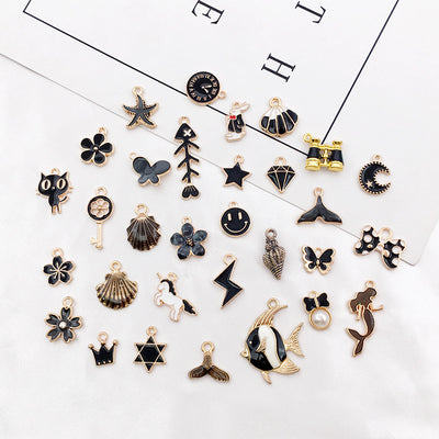 Black seashell charms arranged on a light background