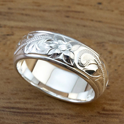 Product view showing wide silver-tone engraved floral scroll band ring