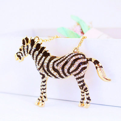 Front view of a black striped zebra charm covered with clear rhinestones and gold-tone edging.