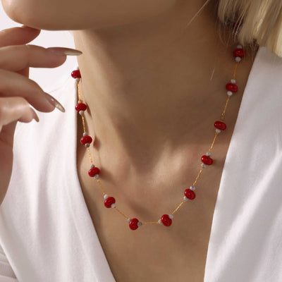 Model wears red natural stone disk bead gold chain necklace