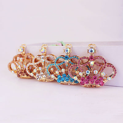 Four gold-tone crown charms show peach, clear, blue, and pink rhinestone colorways.