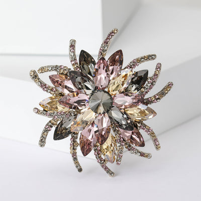 Front view of radiating crystal flower brooch with layered marquise stones against a white background.