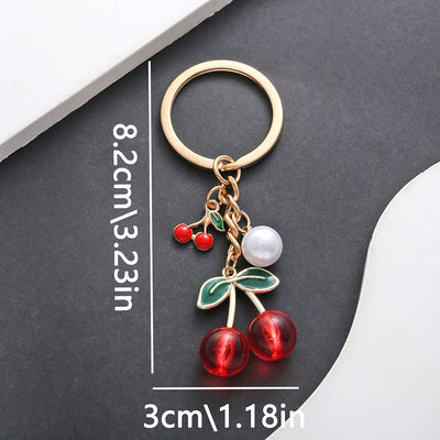 Front product photo of transparent red and black cherry pearl keychain showing the pictured design arrangement