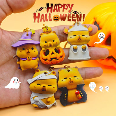 Five Halloween capybara wood charms held in hand under banner