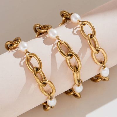 Gold oval link bracelets with white shell beads on fabric roll