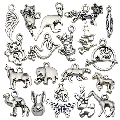 Antique silver elephant charms arranged on a light background