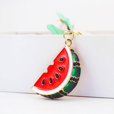 Close-up of a red watermelon slice charm with a green rind and black seed-shaped accents.