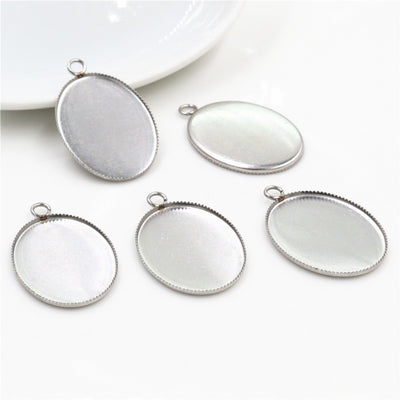 plain oval cabochon pendant trays arranged together on a white background