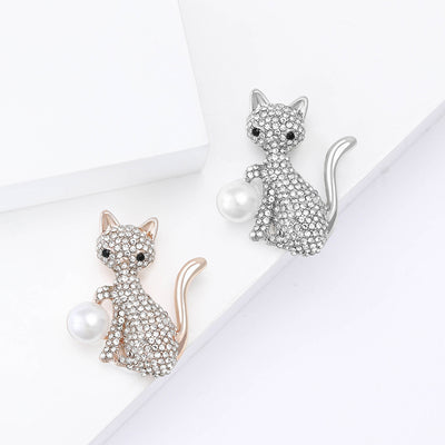 Front view of the crystal cat brooch holding a large pearl decorative clothing pin on a white background