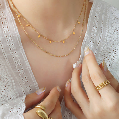 Model wearing gold double-layer rhombus charm necklace with rings