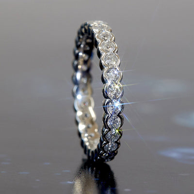 Product view showing bezel-set round clear stone eternity ring silver tone