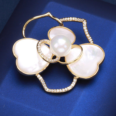 Front view of white shell effect double flower brooch against a white background.