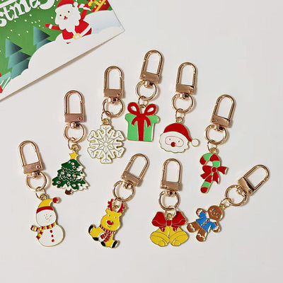Nine colorful Christmas enamel keychain charms with gold clasps grouped together