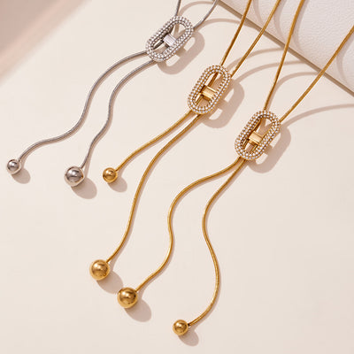 Gold and steel oval zircon slider Y-necklaces with ball tips flat lay