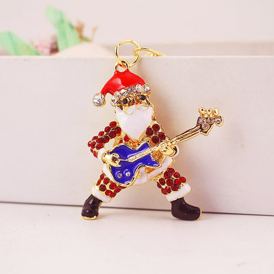 Close-up front view of a rhinestone Santa figure playing a blue guitar.